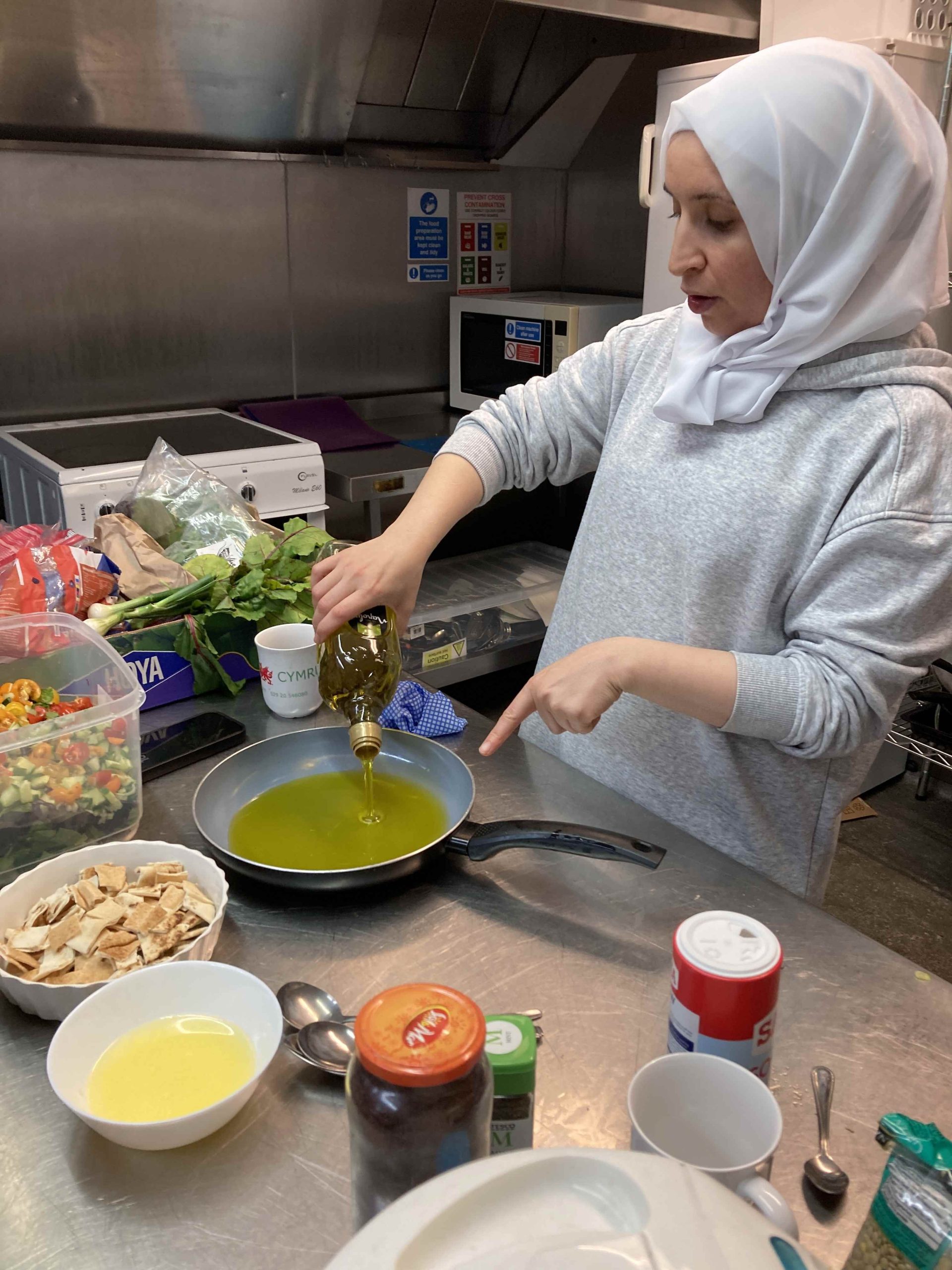Person pouring oil in a pan