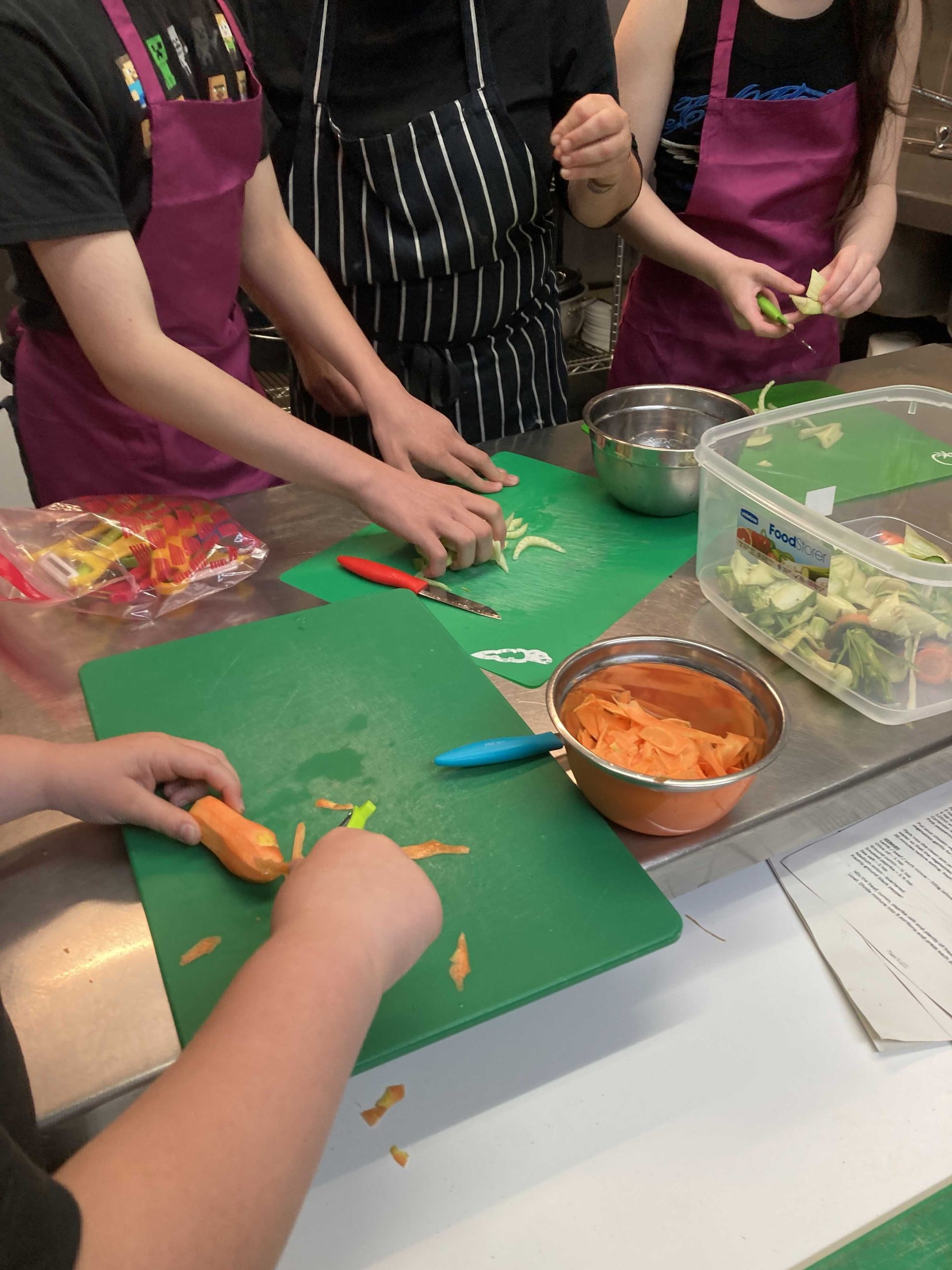 Several people chopping veg